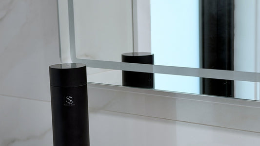 Black Tower Diffuser on a marble bathroom vanity beside a mirror, as used in luxury hotels